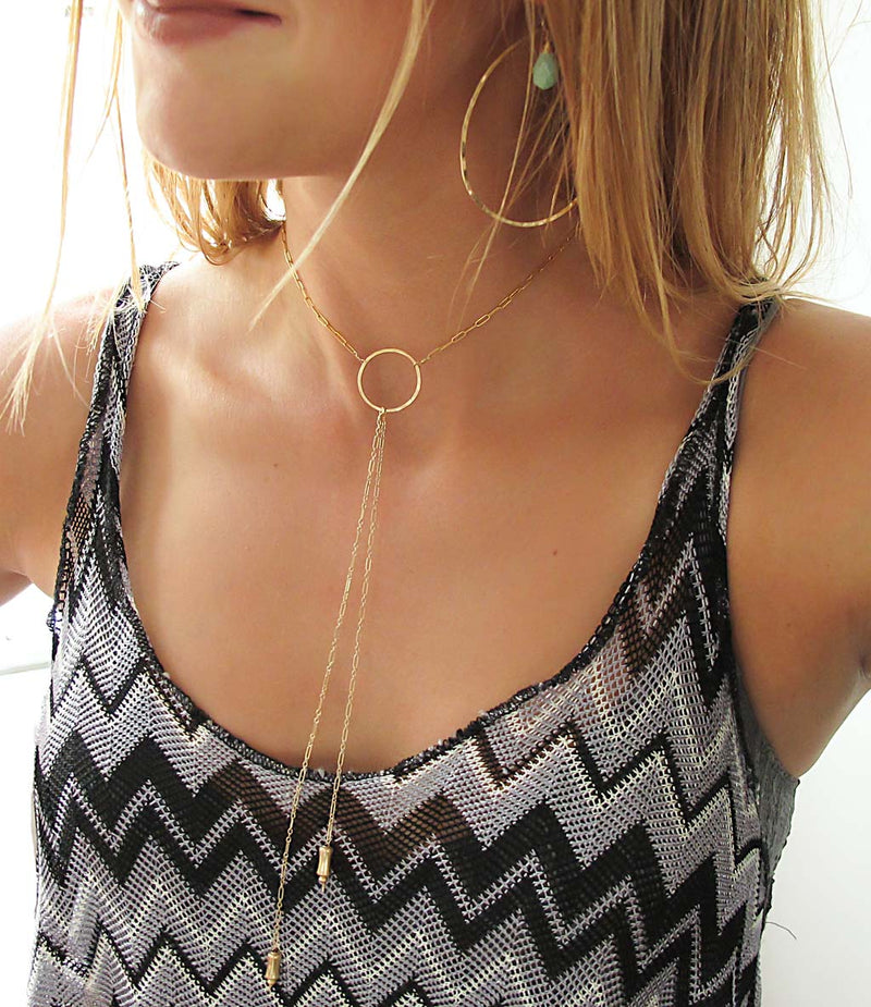 blond woman on a black grey and white stripes top wearing a 14k gold filled bolo y necklace
