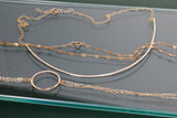 delicate gold necklaces on a table by delia langan jewelry