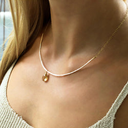 champagne quartz and thin delicate gold arc necklace on girls neck