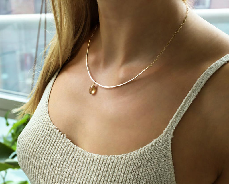 champagne quartz and thin delicate gold arc necklace on girls neck
