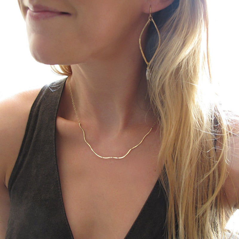 blond woman on a dark green top wearing a 14k gold filled coastal route necklace