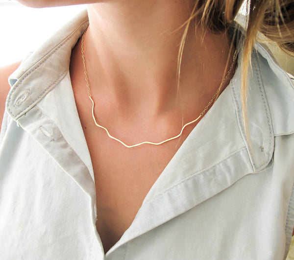blond woman on a white shirt neck closeup wearing a 14k gold filled coastal route necklace