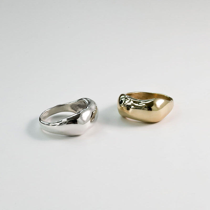 brass and sterling silver curve rings on white surface