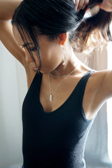 black woman on a black tank holding her hair up wearing a sterling silver different strokes fringe pendant necklace