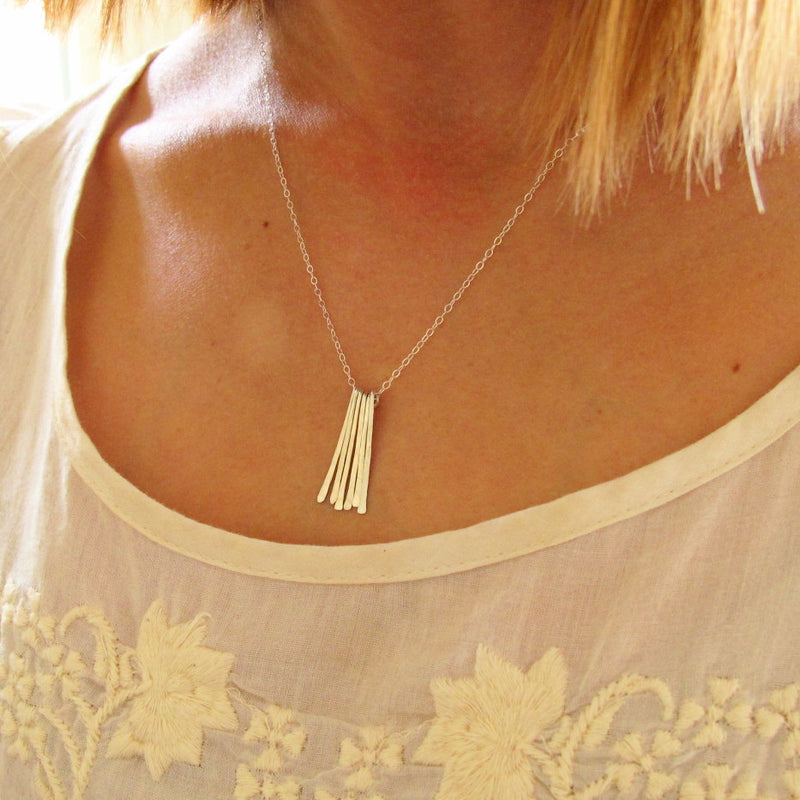 blond woman on a white tshirt wearing a sterling silver different strokes fringe pendant necklace