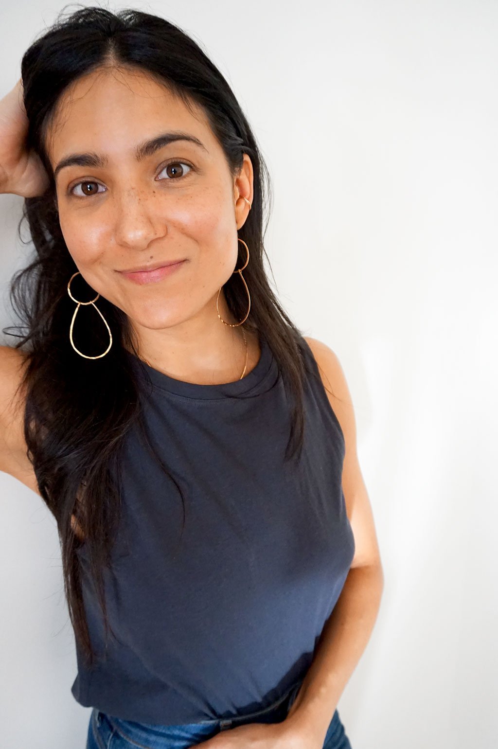brunette wearing 14k gold filled long double drop hoop earrings and 14k gold filled stacked cartilage hoop earrings