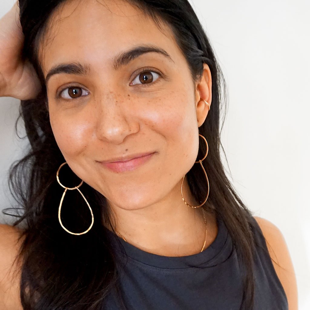 brunette face closeup wearing 14k gold fill long double drop hoop earrings and 14k gold fill stacked cartilage hoop earrings