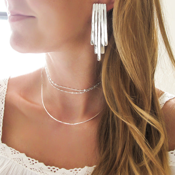 blond woman neck closeup wearing sterling silver empire earrings and a sterling silver xl scenic route necklace 
