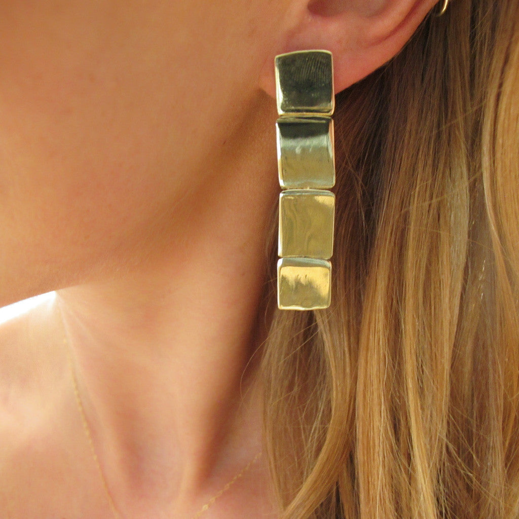 blond woman ear closeup wearing gold brass four square post earrings 