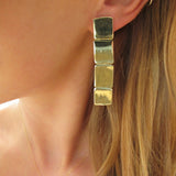 blond woman ear closeup wearing gold brass four square post earrings 
