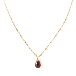 delicate gold and garnet pendant by delia langan jewelry