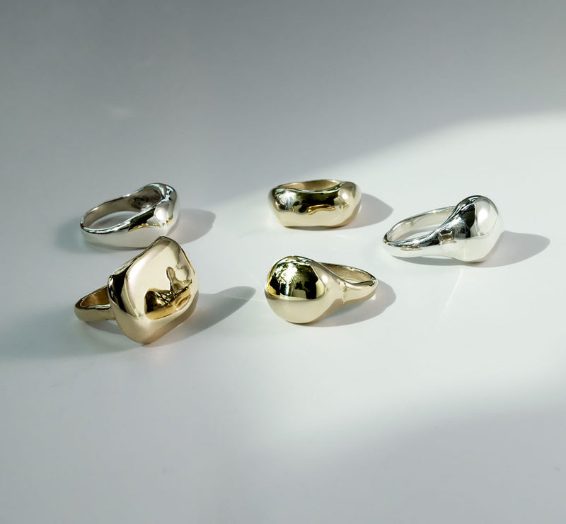 globe plateau and curve rings on silver and gold colors on white surface