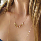 blond woman neck closeup wearing a 14k gold filled gold grain necklace