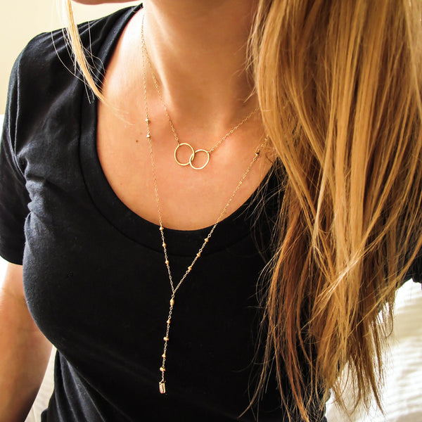 blond woman on a black tshirt wearing a 14k gold filled prism y necklace