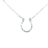 shining horseshoe closeup of a sterling silver good luck horseshoe necklace under a bright light