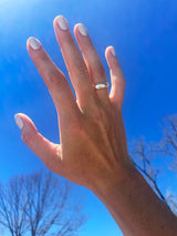 hand against blue sky with chunky silver ring