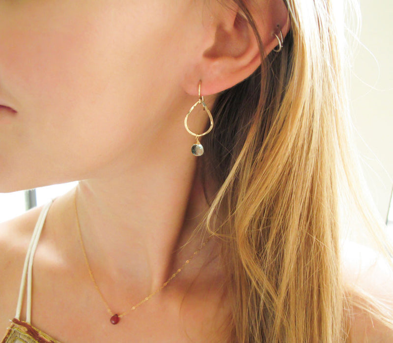 blond woman ear closeup wearing 14k gold filled green amethyst teardrop gemstone earrings