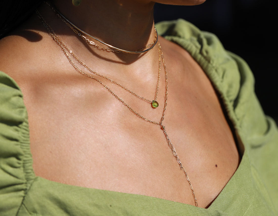 small green peridot pendant layered with delicate y shaped necklace