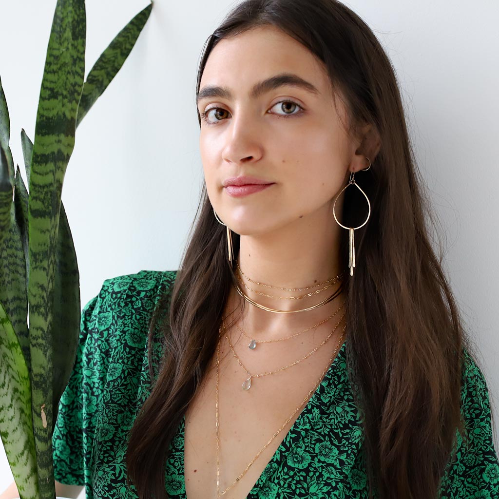 girl in green wearing delicate layered jewelry