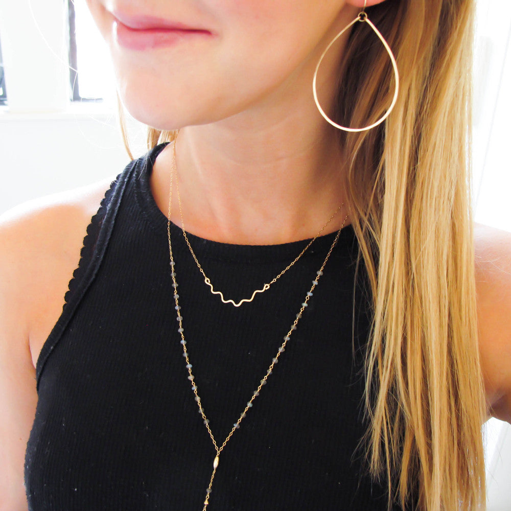 blond woman on a black tshirt wearing 14k gold filled large teardrop hoop earrings
