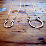 tiny gold horseshoe pendants by delia langan jewelry