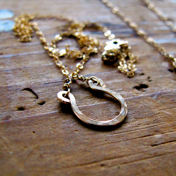 tiny gold horseshoe pendant by delia langan jewelry