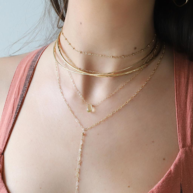 woman neck close up wearing 14k gold filled lemon quartz short gemstone necklace ball chain choker necklace and halo collars