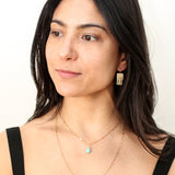 brunette wearing brass jellyfish drop earrings and a 14k gold filled chalcedony gemstone beaded pendant