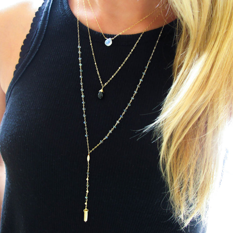 blond woman on a black top wearing a 14k gold filled black spinel gemstone beaded pendant