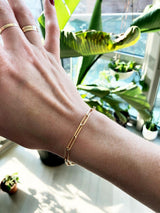 woman wrist wearing 14k gold filled large link chain bracelet and solid 14k gold rings on middle and ring fingers