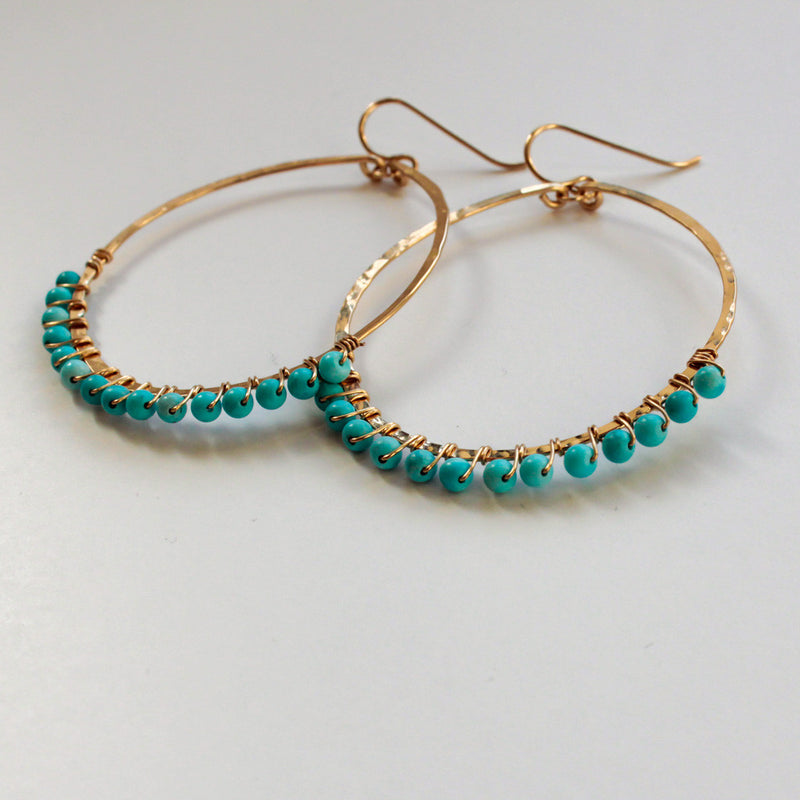 side view of wire wrapped turquoise 14k gold filled hammered hoop earrings handmade by delia langan