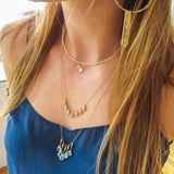 blond woman on a blue top wearing a 14k gold filled gold grain necklace