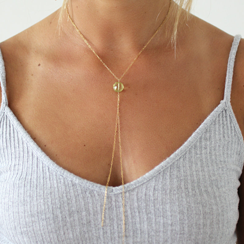 blond woman on a white top wearing a 14k gold filled lemon quartz y gemstone necklace 