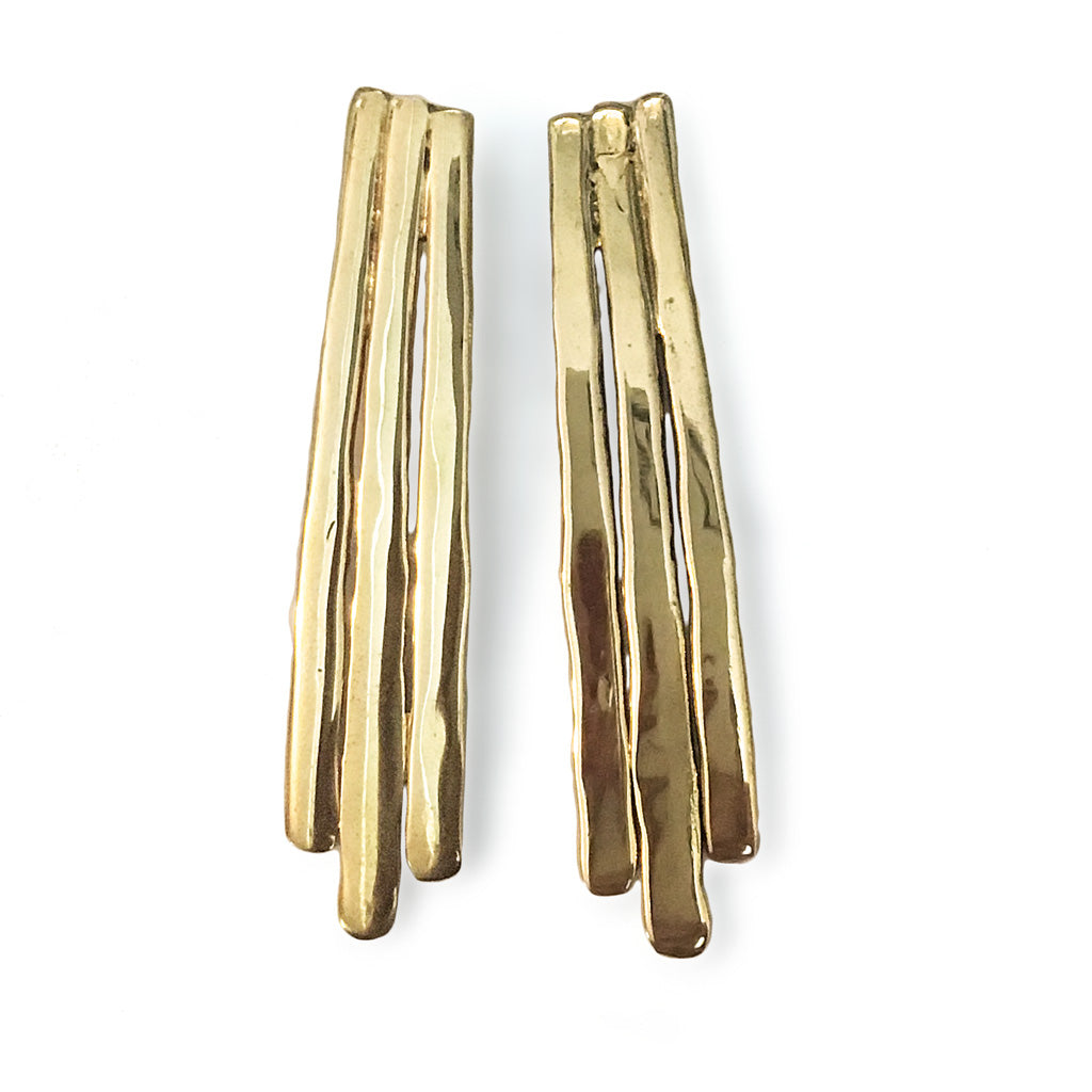 gold brass long fringe post earrings on white surface 