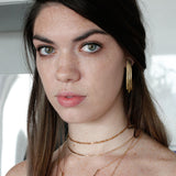green eyes brunette looking at camera wearing gold brass long fringe post earrings