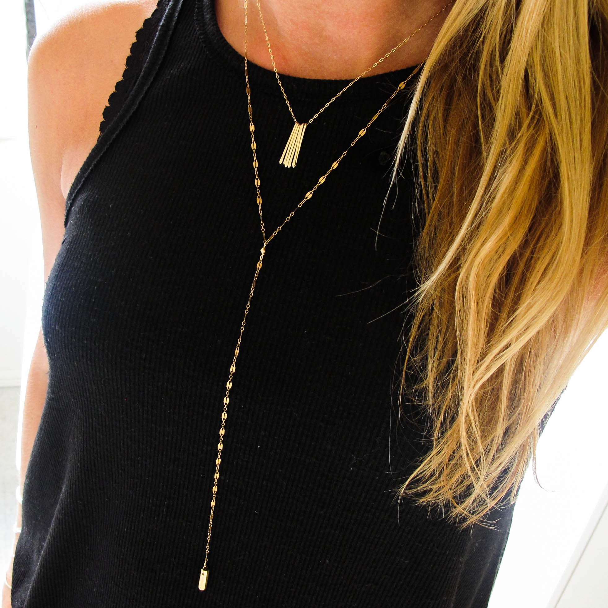 blond woman on a black top wearing a 14k gold filled prism y necklace