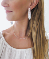 blond woman neck closeup wearing sterling silver long fringe post earrings 