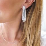 blond woman ear closeup wearing sterling silver long fringe post earrings 