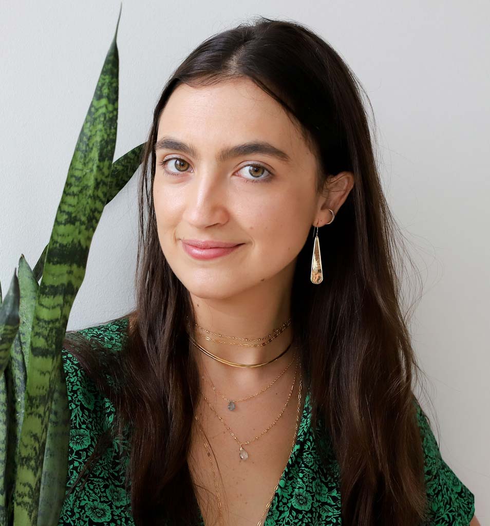 brunette wearing brass xl teardrop earrings green amethyst gemstone beaded pendant and moss aquamarine short gemstone necklace