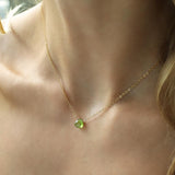 woman neck close up wearing a 14k gold filled peridot short gemstone necklace