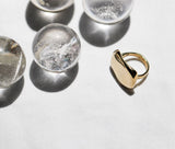 Big golden brass ring closeup with crystal spheres over a white fabric background 