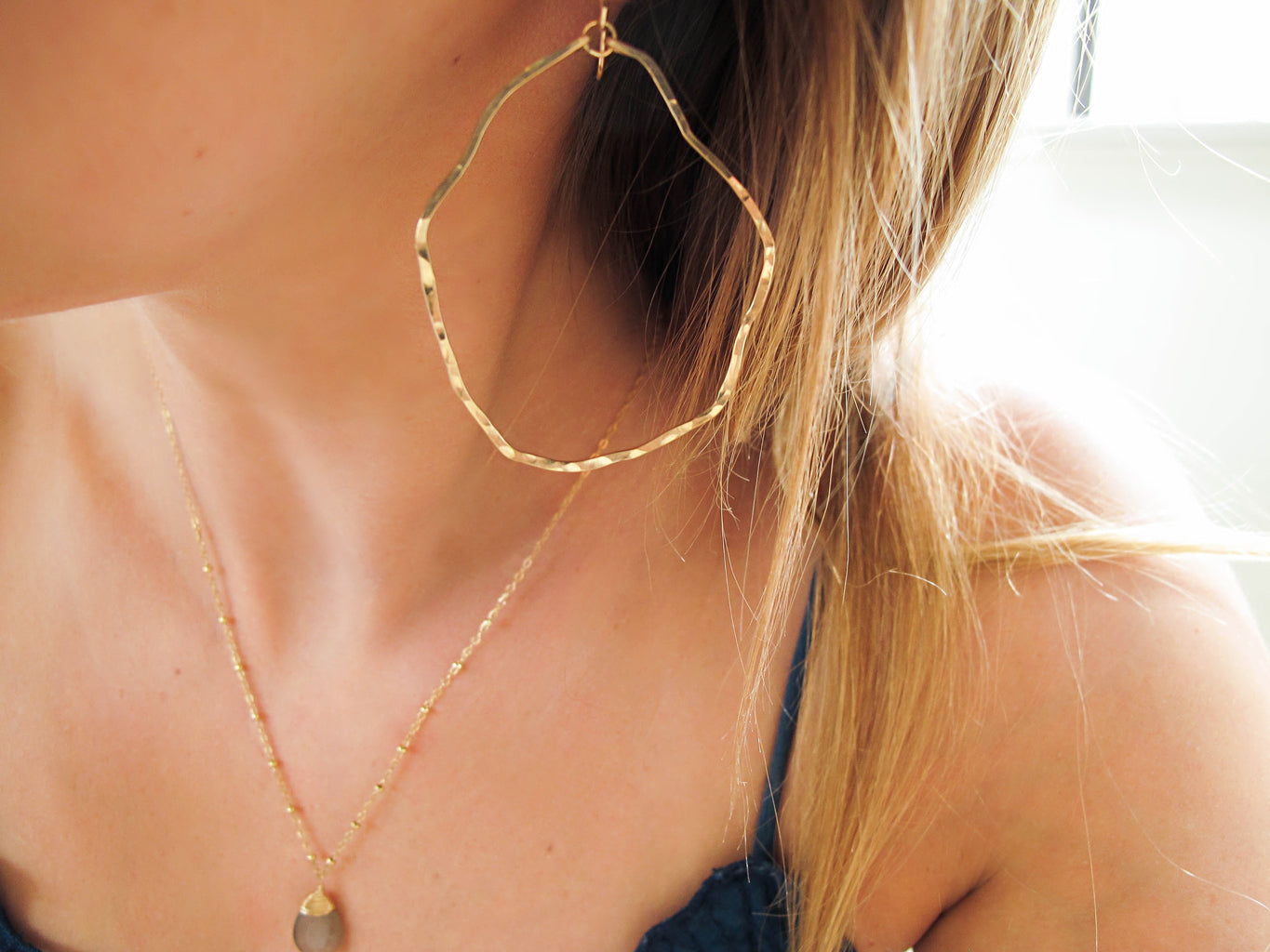 blond woman ear closeup wearing 14k gold filled potatohead hoop earrings