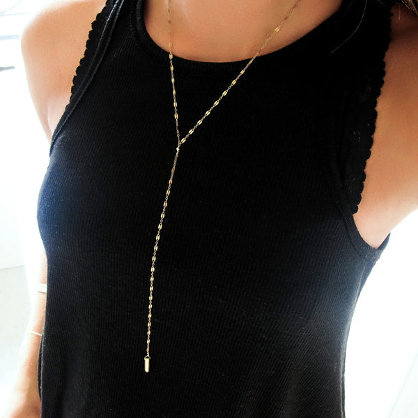 woman on a black top wearing a 14k gold filled prism y necklace