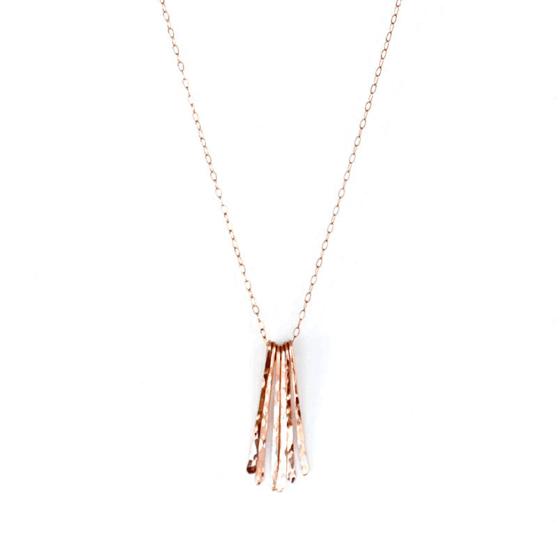 rose gold filled different strokes fringe pendant necklace on a white surface