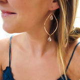 blond woman on a blue top wearing rose quartz rose gold leaf gemstone earrings