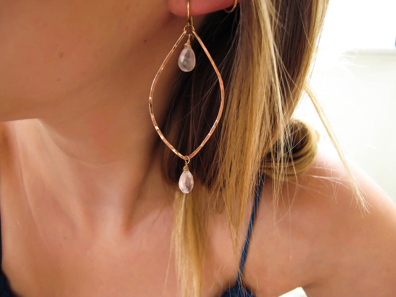 blond woman on a blue top ear closeup wearing rose quartz rose gold leaf gemstone earrings