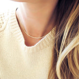 thin gold necklace under cable knit sweater by delia langan jewelry necklace for sweater neckline