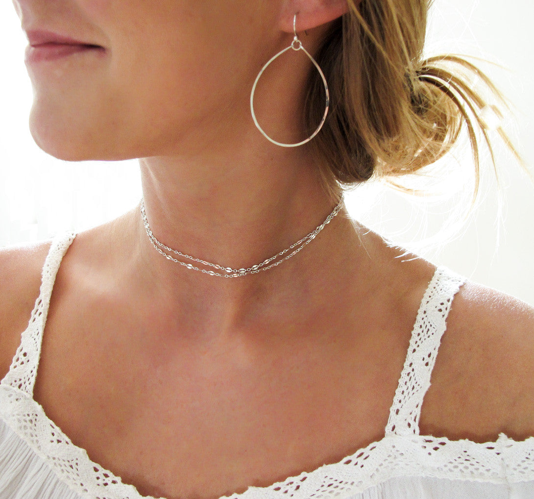 blond woman on a white top wearing sterling silver hoops for nuns hoop earrings