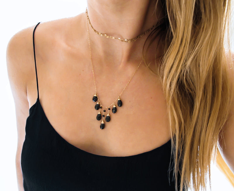black spinel and gold necklace with black tank top by delia langan jewelry