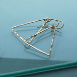 gold triangle earrings by delia langan jewelry